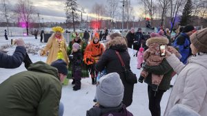 Vuodenajat-valohahmot lastentapahtumassa talvella, ihmisiä ympärillä valokuvaamassa ja ihastelemassa