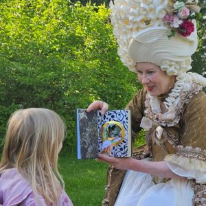 Kuningatar LorUlla kädessään dioraamakirja satuhetkellä